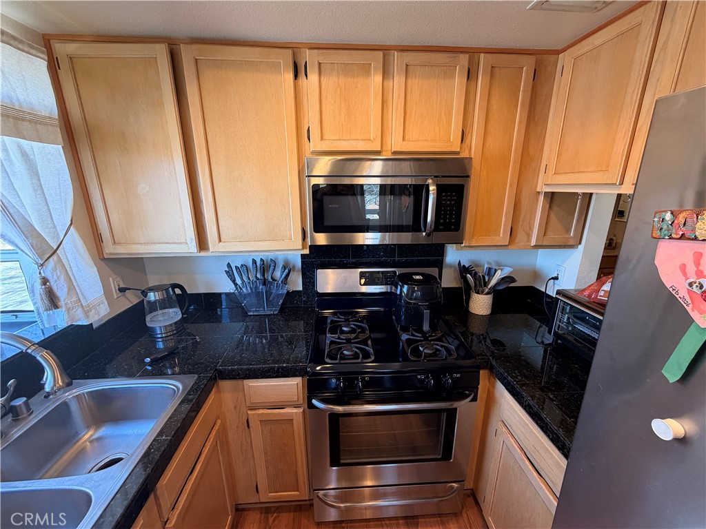 19804 Sandpiper Place, Unit 9 Newhall, CA 91321 - Photo 10 of 27 a kitchen with stainless steel appliances granite countertop a sink stove and microwave