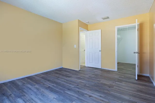an empty room with wooden floor and closet