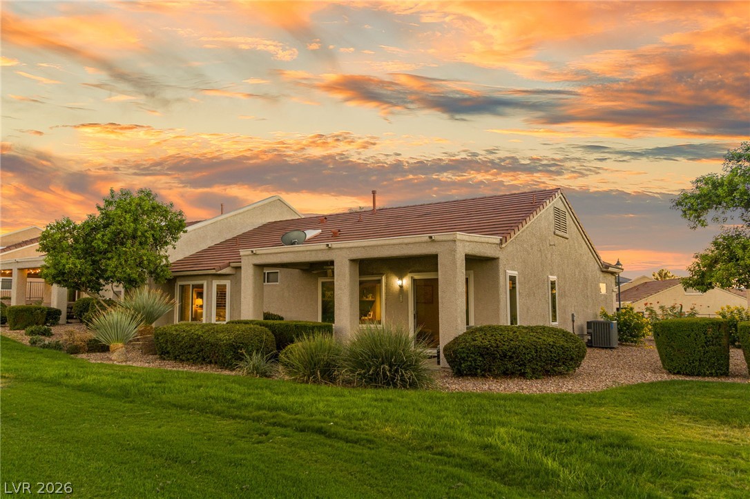 2738 Grand Forks Road Henderson, NV 89052 - Photo 3 of 52 Manicured green lawns frame this desert home featuring a covered patio and tile roof.