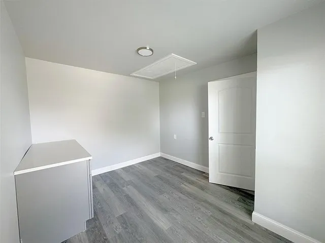 an empty room with wooden floor and closet
