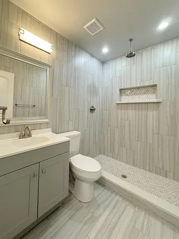 a bathroom with a sink a toilet and shower