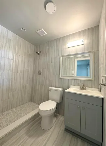 a bathroom with a sink toilet a mirror and shower