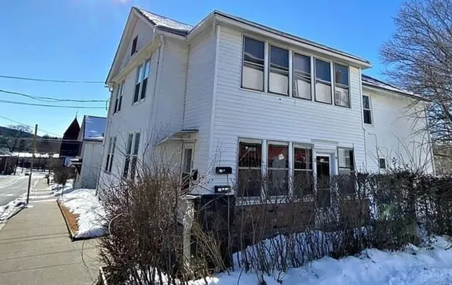 a front view of house with yard and trees around