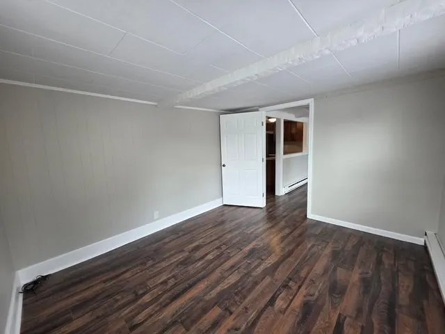a view of empty room with wooden floor and ceiling fan