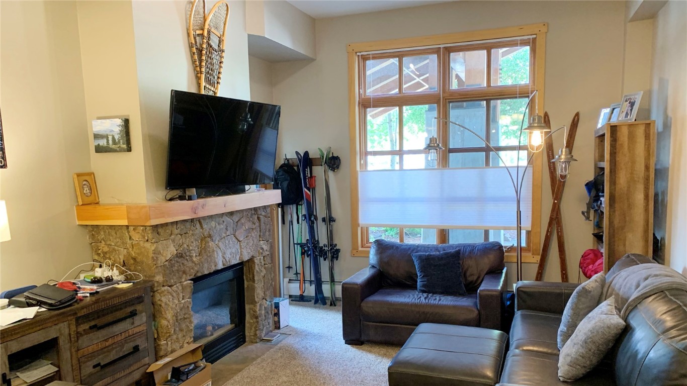 910 Copper Road, Unit 122 Copper Mountain, CO 80443 - Photo 3 of 25 a living room with furniture a flat screen tv and a fireplace