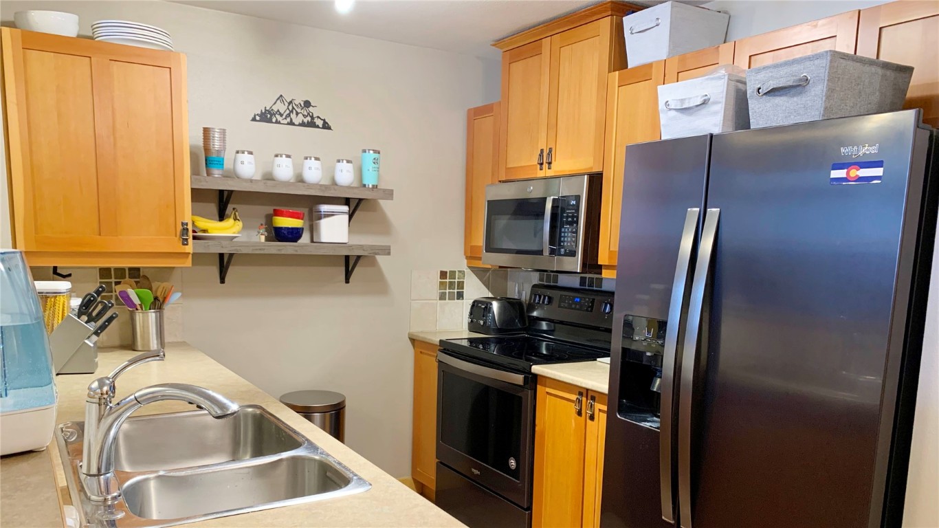 910 Copper Road, Unit 122 Copper Mountain, CO 80443 - Photo 6 of 25 a kitchen with stainless steel appliances a sink a stove and a refrigerator