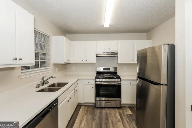 a kitchen with a refrigerator stove and sink