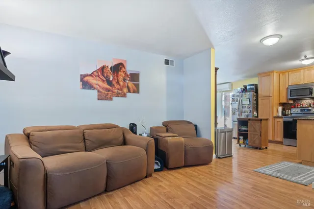 a living room with furniture and a kitchen view