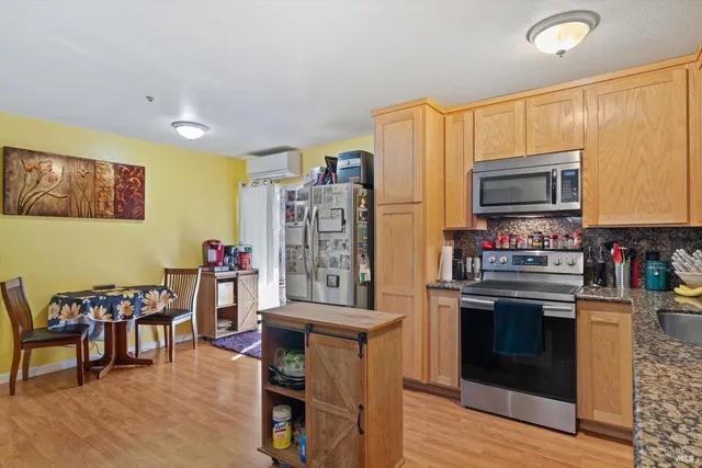 a kitchen with granite countertop a stove and chairs