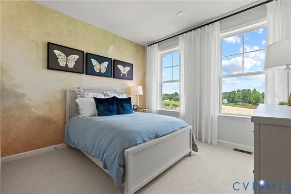 a bed sitting in a bedroom next to a window