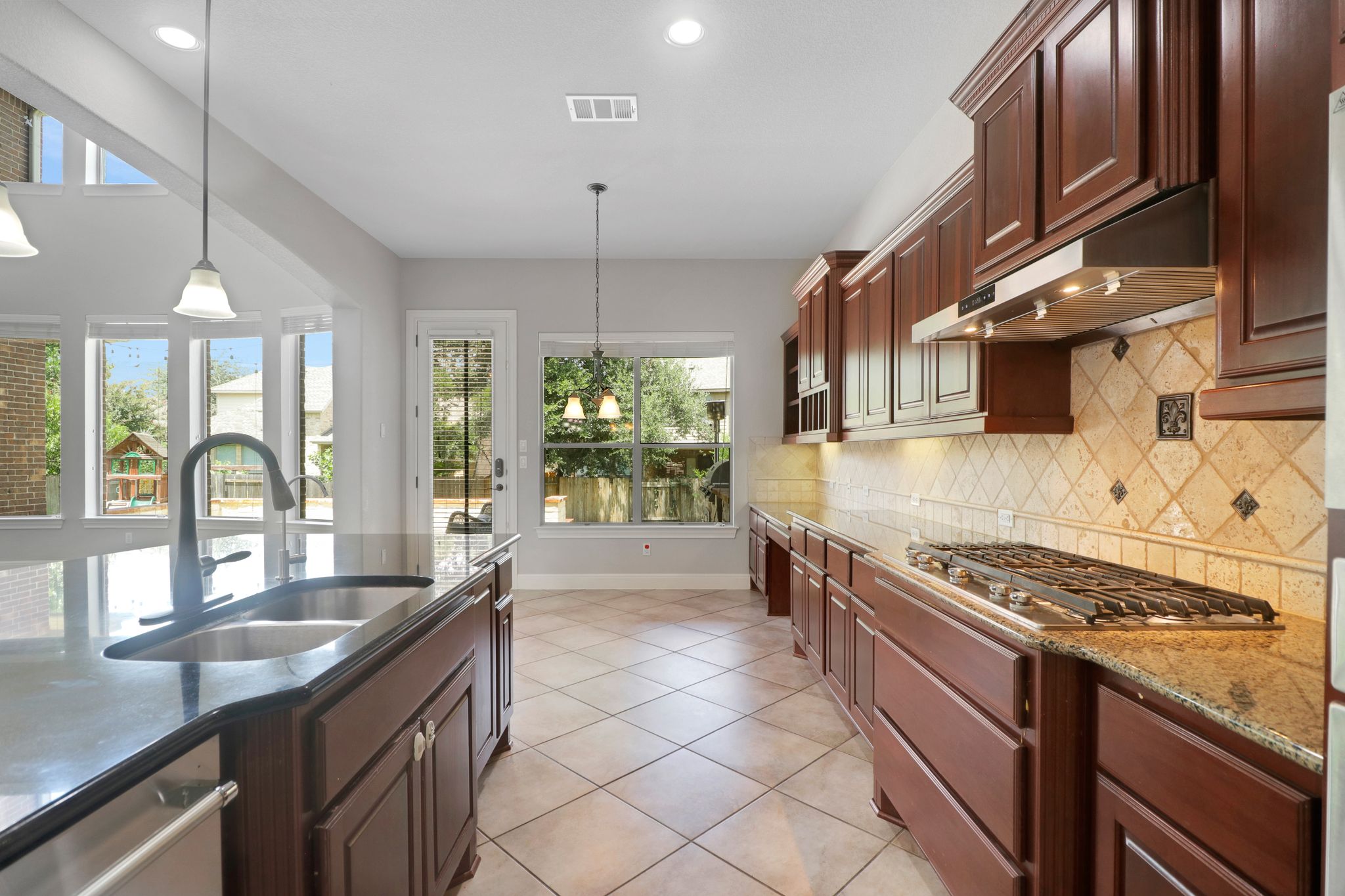 3913 Remington Road Cedar Park, TX 78613 - Photo 15 of 32 Rich wood cabinetry and tile flooring define this bright, open kitchen space.