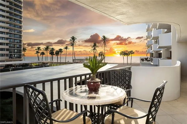 a view of a balcony dining area and swimming pool
