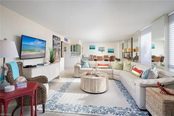 a living room with furniture a flat screen tv and large window