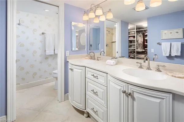 a bathroom with a granite countertop sink a mirror a vanity and bathtub