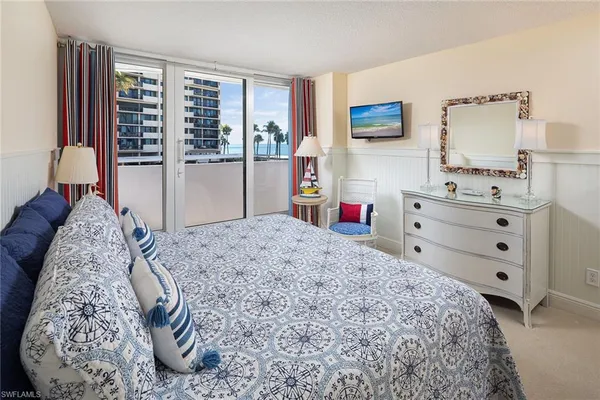 a bedroom with a bed and dresser with mirror