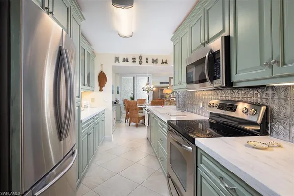 a kitchen with stainless steel appliances granite countertop a stove a sink and a refrigerator