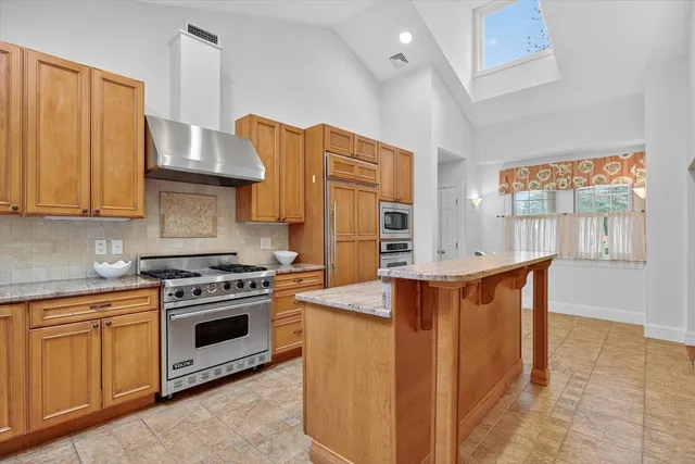 a kitchen with stainless steel appliances granite countertop a stove a sink dishwasher and a refrigerator