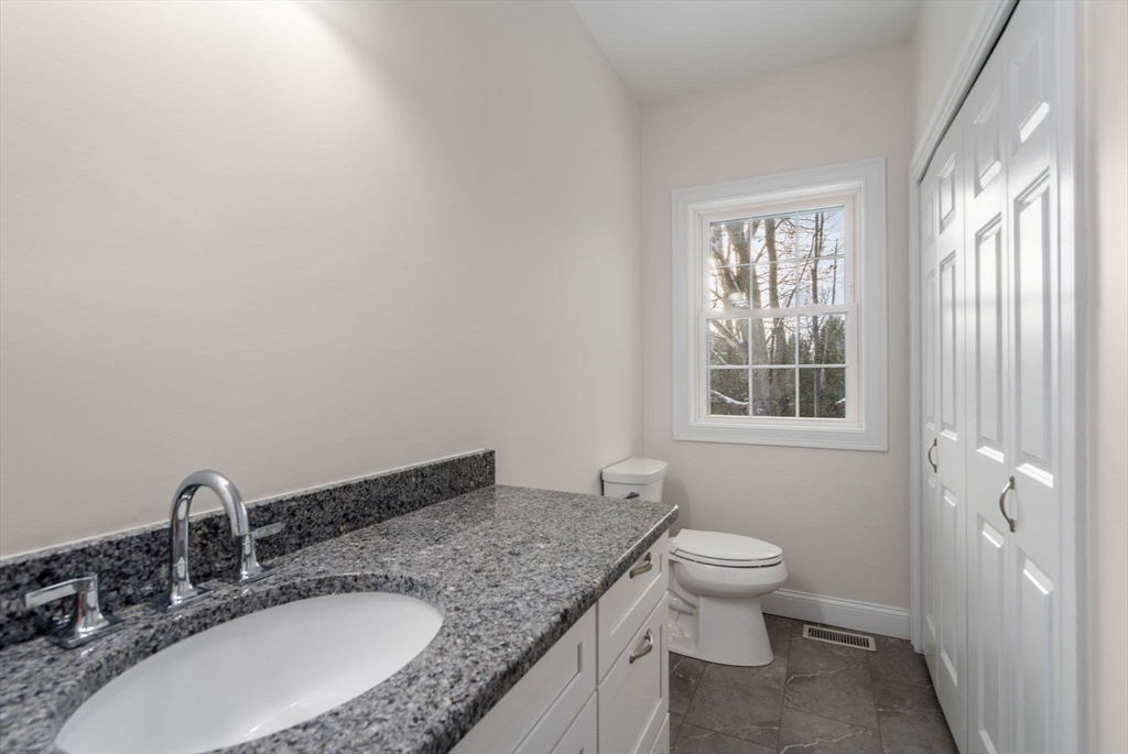 5 Miles Road Rutland, MA 01543 - Photo 17 of 37 a bathroom with a granite countertop sink a toilet and a window