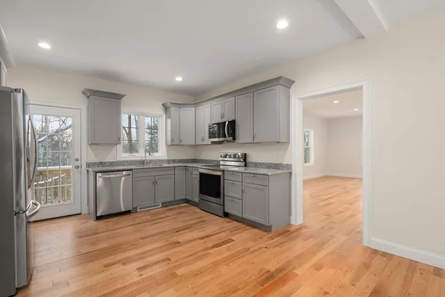 a kitchen with granite countertop a stove top oven sink and cabinets