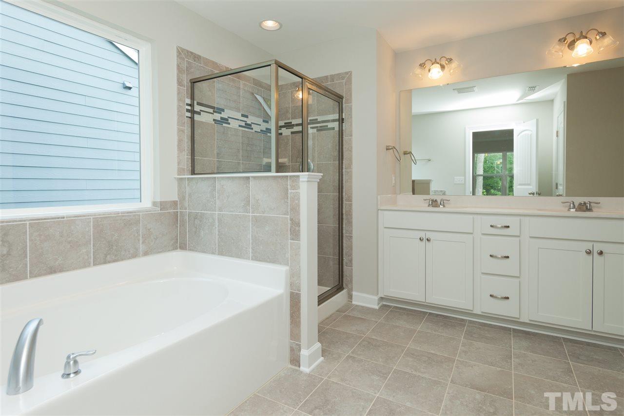 113 Spring Pine Lane Holly Springs, NC 27540 - Photo 13 of 25 a bathroom with a bathtub and a sink