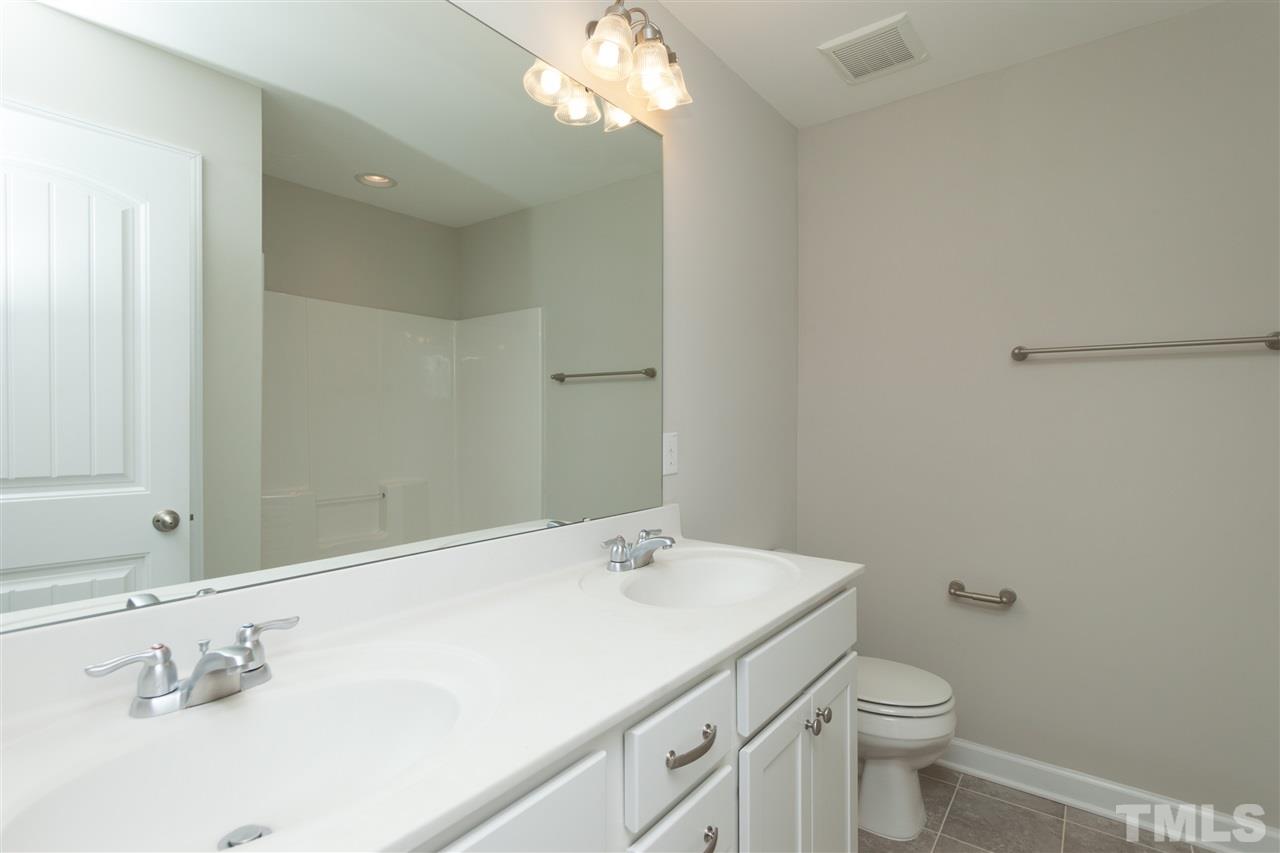 113 Spring Pine Lane Holly Springs, NC 27540 - Photo 20 of 25 a bathroom with a toilet sink and mirror