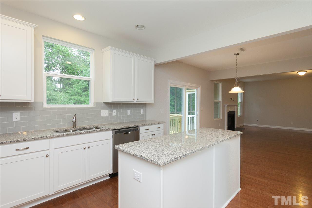 113 Spring Pine Lane Holly Springs, NC 27540 - Photo 6 of 25 a kitchen with a sink cabinets and window