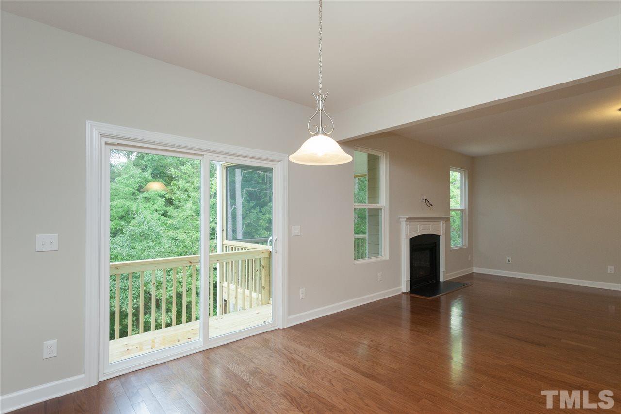 113 Spring Pine Lane Holly Springs, NC 27540 - Photo 7 of 25 a view of an empty room with wooden floor and a window