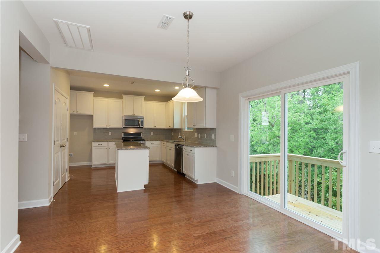 113 Spring Pine Lane Holly Springs, NC 27540 - Photo 10 of 25 a open kitchen with white cabinets and white appliances
