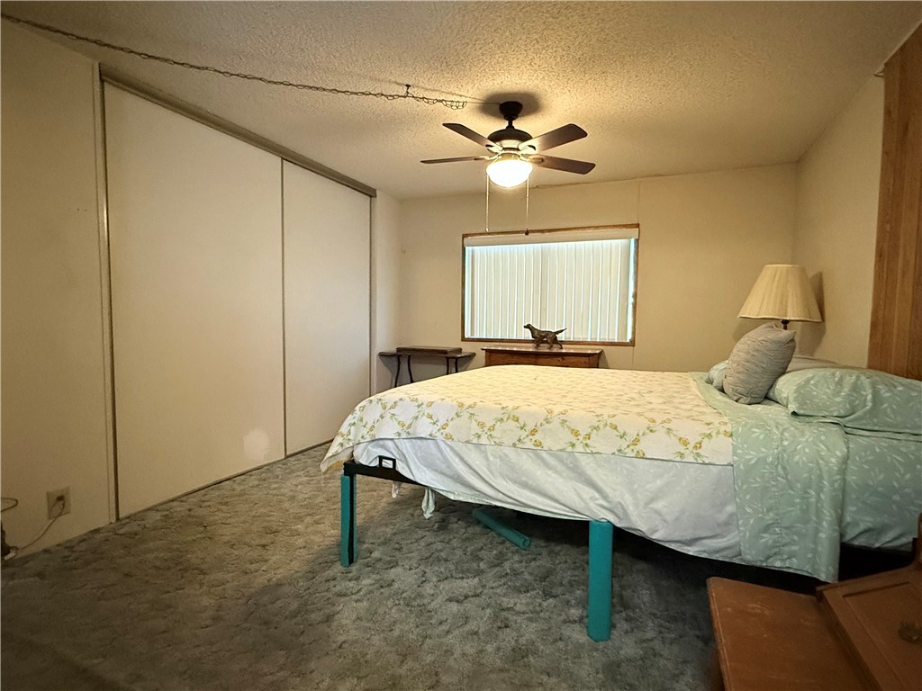 1637 Talc Road Bullhead City, AZ 86442 - Photo 19 of 37 Bedroom featuring a textured ceiling, a closet, carpet flooring, and ceiling fan