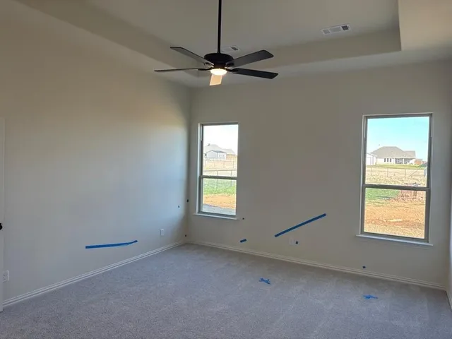 en empty room with windows and chandelier fan