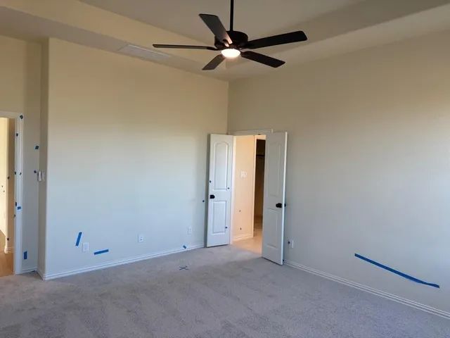 an empty room with a ceiling fan and a window