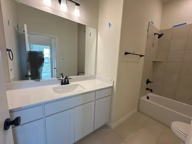 a bathroom with a tub sink toilet and a mirror