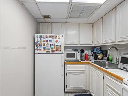 a kitchen with white cabinets and white appliances