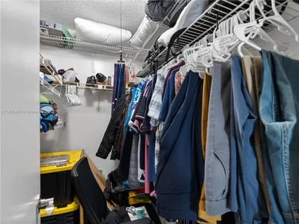 a view of walk in closet with clothes and shoes