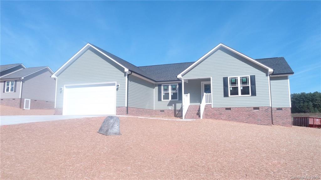 a front view of a house with a yard outdoor seating and garage