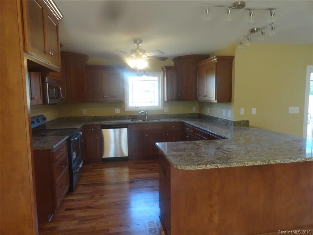 4767 Kemp Dellinger Road, Unit 2 Maiden, NC 28650 - Photo 6 of 21 a kitchen with granite countertop a sink a counter top space and cabinets