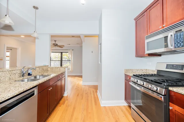 a kitchen with stainless steel appliances granite countertop a sink stove and cabinets