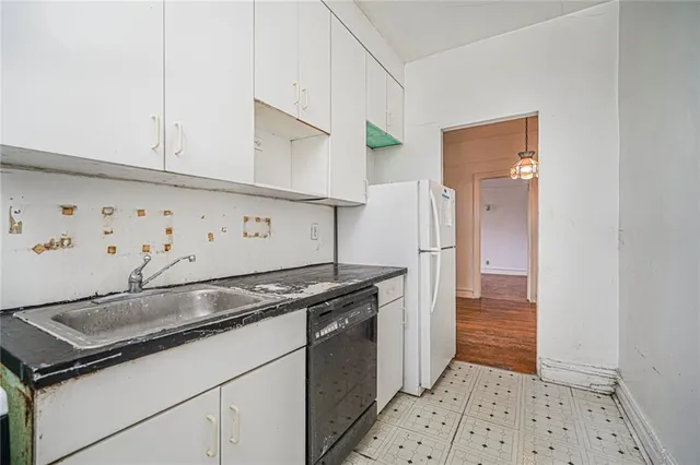 a kitchen with granite countertop a sink and a refrigerator