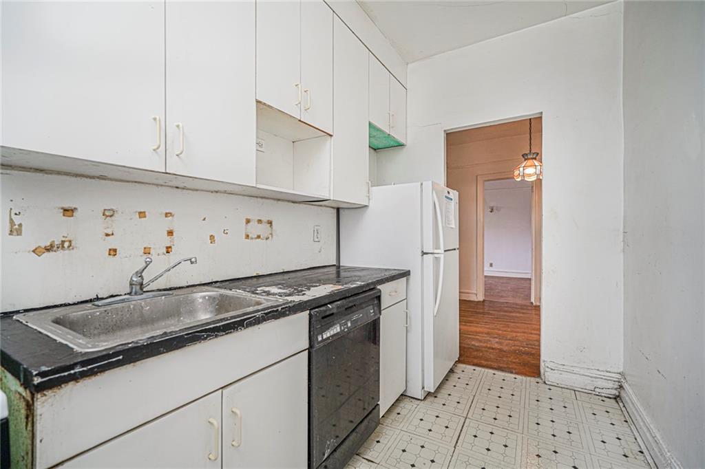 255 79th Street, Unit B2 Brooklyn, NY 11209 - Photo 18 of 22 a kitchen with granite countertop a sink and a refrigerator