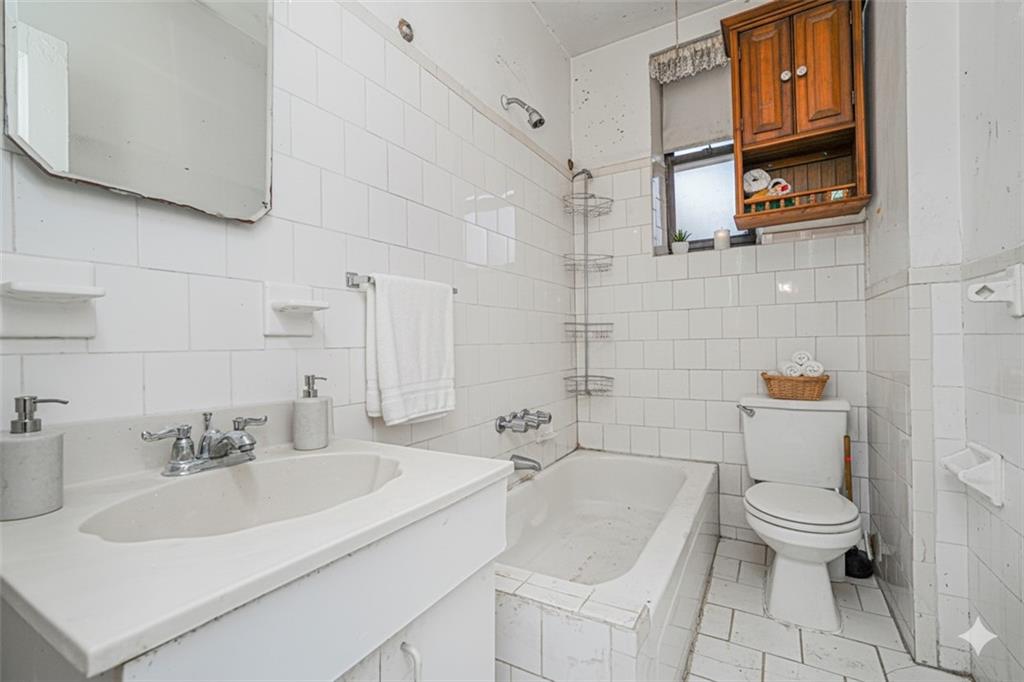 255 79th Street, Unit B2 Brooklyn, NY 11209 - Photo 5 of 22 a bathroom with a sink a toilet and shower