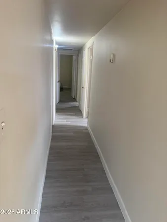 a view of a hallway with wooden floor and staircase