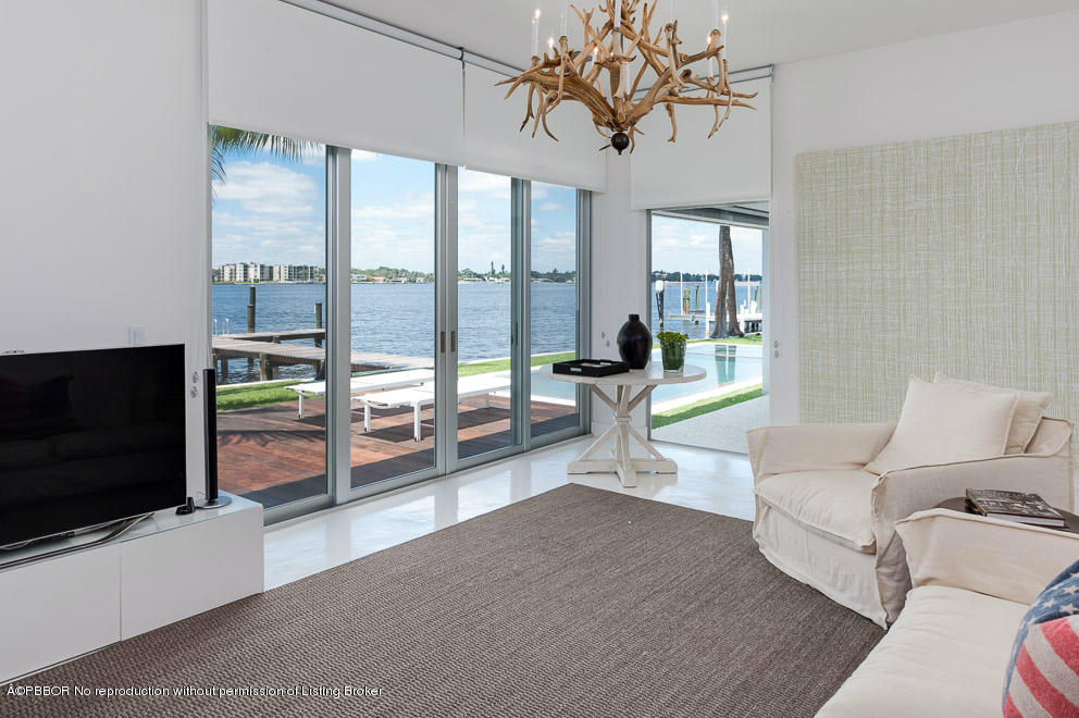 1225 Lands End Road Manalapan, FL 33462 - Photo 21 of 28 a living room with furniture a flat screen tv and a floor to ceiling window