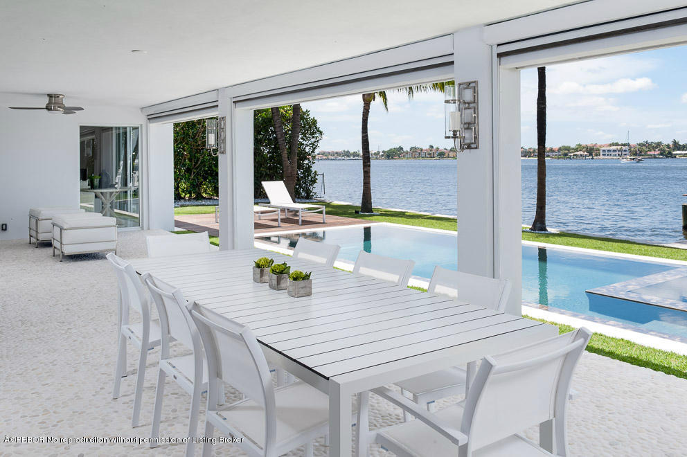 1225 Lands End Road Manalapan, FL 33462 - Photo 23 of 28 a view of a dining room with furniture large windows and a chandelier