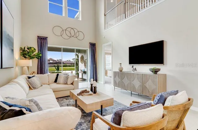 a living room with furniture a flat screen tv and a floor to ceiling window