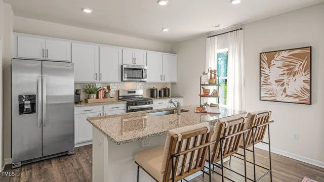a kitchen with stainless steel appliances granite countertop a stove a microwave and cabinets
