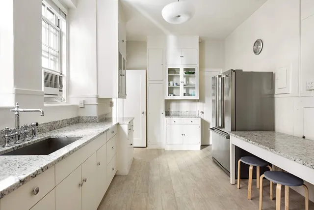 a kitchen with granite countertop a refrigerator and a sink