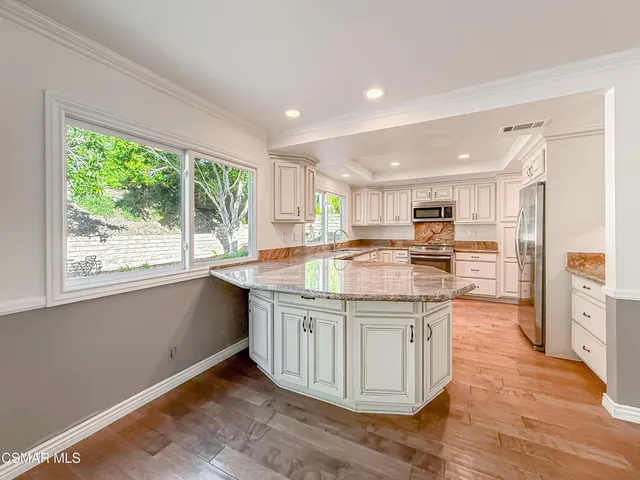 a kitchen with granite countertop white cabinets white appliances and a sink