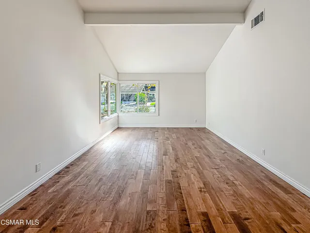a view of a room with wooden floor windows and entryway