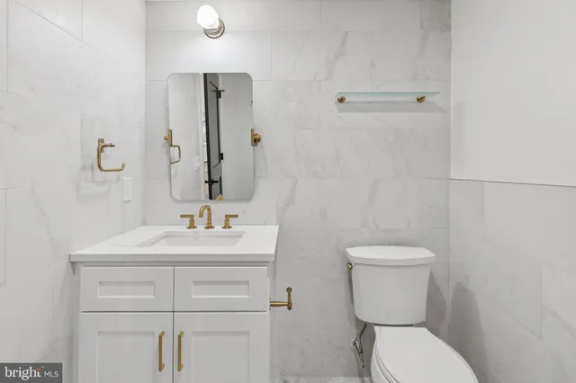 a bathroom with a sink a toilet and mirror