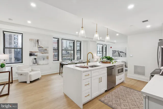 a kitchen with stainless steel appliances kitchen island granite countertop a stove and white cabinets
